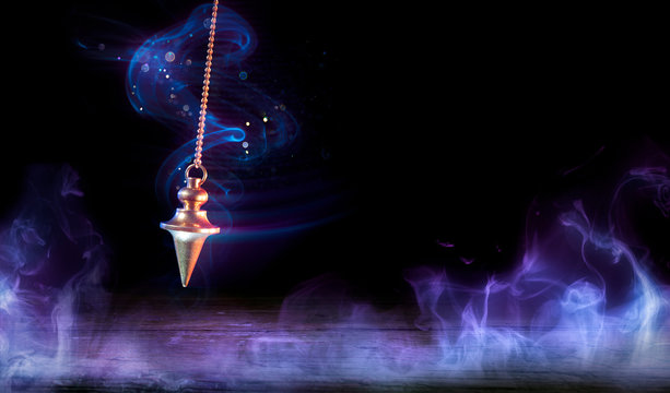 Esoteric And Hypnosis Concept - Pendulum Swinging With Magic Smoke
