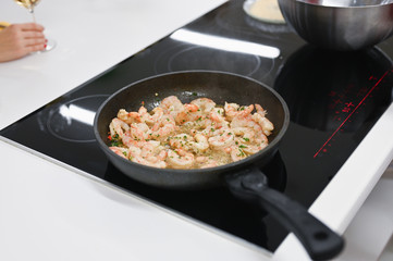 the cook is cooking langoustines. cook in the kitchen. wild shrimp.