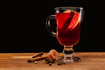 Glass of mulled wine with spices on a dark background