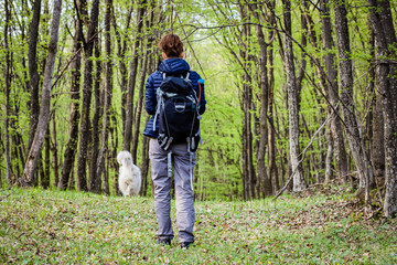 woman trekking alone in green forest