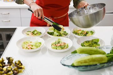 the cook spreads the cooked salad. vegetarian food. cook in the kitchen.