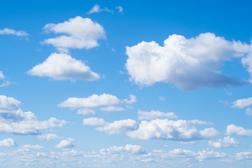 White aerial clouds on a blue sky. Clear good weather. Landscape. Background from the bright blue sky. A lot of clouds in the sky.