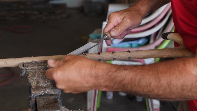 the walking stick maker makes sticks using his hands