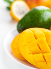 Fresh sweet mango and green avocado on white background. Exotic tropical fruits for healthy and vegeterian diet.
