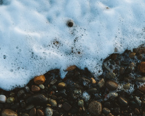 Sea foam on a pebble beach