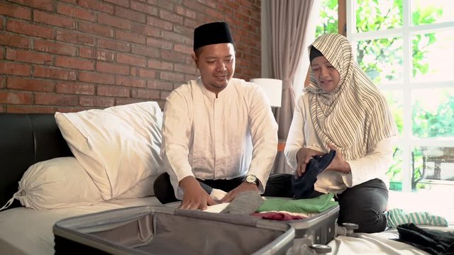 happy muslim couple packing for holiday