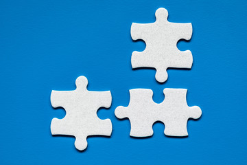 Obraz premium White jigsaw puzzle. White puzzle pieces on color background. Unfinished white jigsaw puzzle pieces on color background.