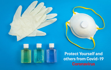 Health care kit for Coronavirus Protect Yourself and Others. Flat lay on blue with mask, hand sanitizer, gloves.