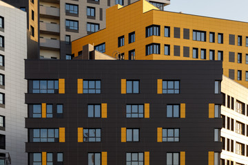 Fragment of a new elite residential building or commercial complex. Part of urban real estate. Modern ventilated facade with windows. Diagonal arrangement.