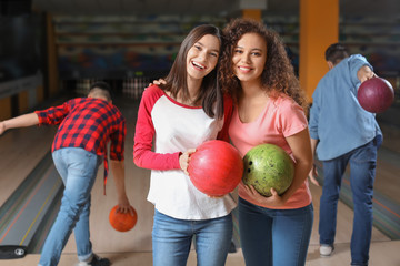 Friends playing bowling in club