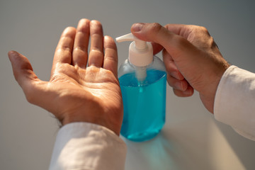 Sanitizer gel. Hand antiseptic. blue bottle of antibacterial product in man's hands on a white background.epidemic of coronavirus. Hygiene and health concept.