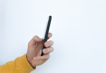 Side view of male hand in a yellow sweater using a smartphone isolated on white background. Social media concept