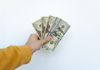 Man in a yellow sweater holding several money bill of 100 and 20 dollars on white background. Concept finance money. Isolated. First-person view