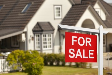 Fototapeta premium Real estate sign in front of new house for sale