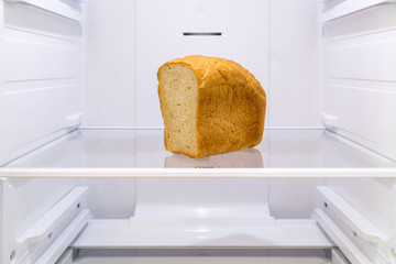 half a loaf of bread on the shelf in the empty refrigerator