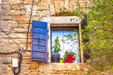 Stone facade with window of ancient house. The Groznjan village on Istria in Croatia, Europe.