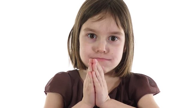 Thank you/praying hands hand gesture. Little girl saying "thank you" with her hands by mimicking the praying hands emoji. White background.