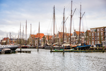 Fototapeta na wymiar Harlingen, Nethrelands - January 10, 2020. Boats in water canal in downtown in winter