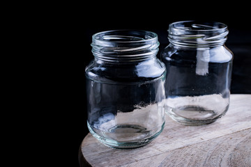 Recycling concept. Two reusable glass jars on a wood.