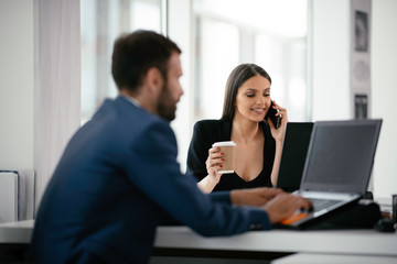 Colleagues working together in office. Young businessman and businesswoman working on project.	
