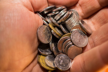 MANO CON MONEDAS PLATA Y ORO 