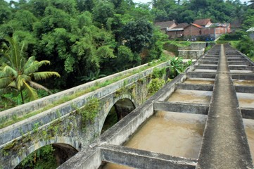 Plakat old bridge over the river in central java, indonesia