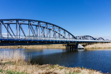 Fototapeta na wymiar Metal bridge background. Road transportation architecture construction. Long bridge over Narew river. Tykocin village in Poland.