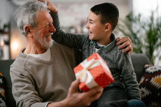 Grandfather giving gift to grandson.	