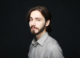 lifestyle and people concept: Portrait of handsome young bearded man on dark background