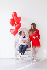 girl and boy with red balloons in the shape of a heart