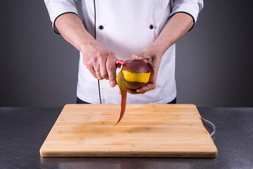 chef slices and peels ripe mango in the restaurant kitchen1
