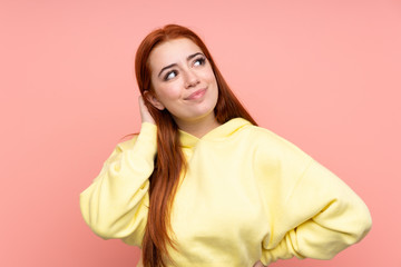 Fototapeta premium Redhead teenager girl over isolated pink background thinking an idea