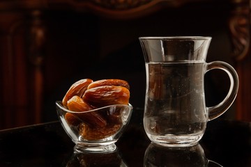 Glass of water and dates on the table. Ramadan fasting Muslims. Concept