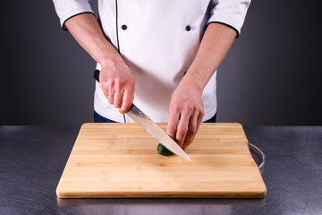 chef cuts cucumber in the restaurant kitchen