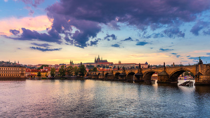 Obraz premium Prague Castle, Charles Bridge and boats on the Vltava river. View of Hradcany Prague Castle, Charles Bridge and a boats on the Vltava river in the capital of the Czechia. Boat cruise on Vltava river.