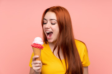 Redhead teenager girl with a cornet ice cream over isolated background