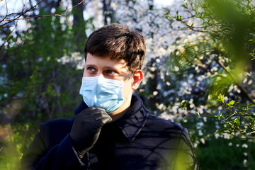 Man in blue medical maskand black gloves outdoor.Protecting health from various viruses and diseases.Quarantine and disease prevention concept.Family protection.