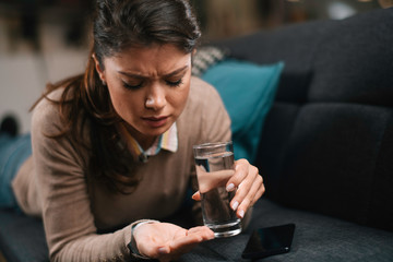 Sick woman at home. Beautiful woman taking medicine.	