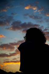 Fototapeta premium A woman in silhouette watches the sky of a beautiful sunset in the city of Rio de Janeiro.