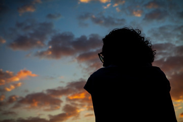 Fototapeta premium A woman in silhouette watches the sky of a beautiful sunset in the city of Rio de Janeiro.