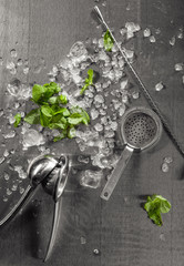 Fototapeta na wymiar Top view picture of crushed ice with cocktail utensils and mint leaves artwork presentation metal background. Cocktail making photography best use for Mexican book menu concept.