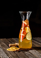 Traditional Mexican punch in a vase like glassware with artistic presentation of dried thin sliced orange on wooden table. Photography best use for magazine or book menu concept.
