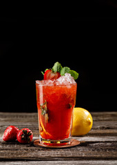 Traditional Mexican beverage in a fancy glass flavored with strawberry with artistic mint leaves presentation on wooden table. Picture best use for Mexican restaurant book menu concept.