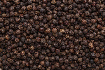 Peppercorn background. Dry black pepper seeds. Top view. Flat design. Macro spice background