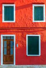 Naklejka premium Lovely house facade and colorful walls in Burano, Venice. Burano island canal, colorful houses and boats, Venice landmark, Italy. Europe