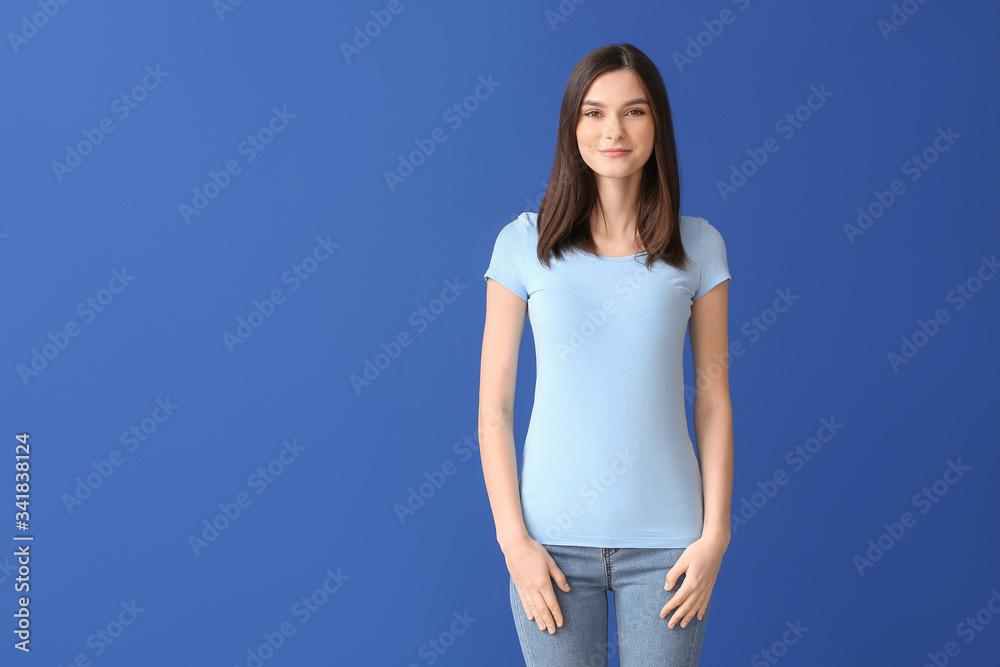 Wall mural Woman in stylish t-shirt on color background