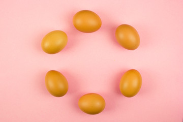 pink background with chicken eggs laid out in a circle, environmentally friendly and correct products, chicken farm and egg production, Easter theme