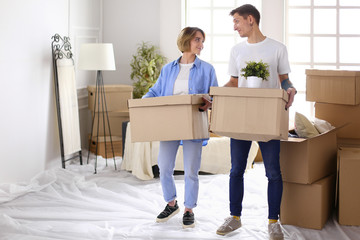 Couple holding boxes for moving the hands and looking inside box