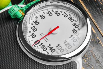 Weight scales on wooden background, closeup. Slimming concept