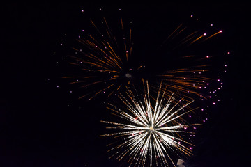 Festive salute in night sky. Explosions of fireworks and pyrotechnics in the sky.